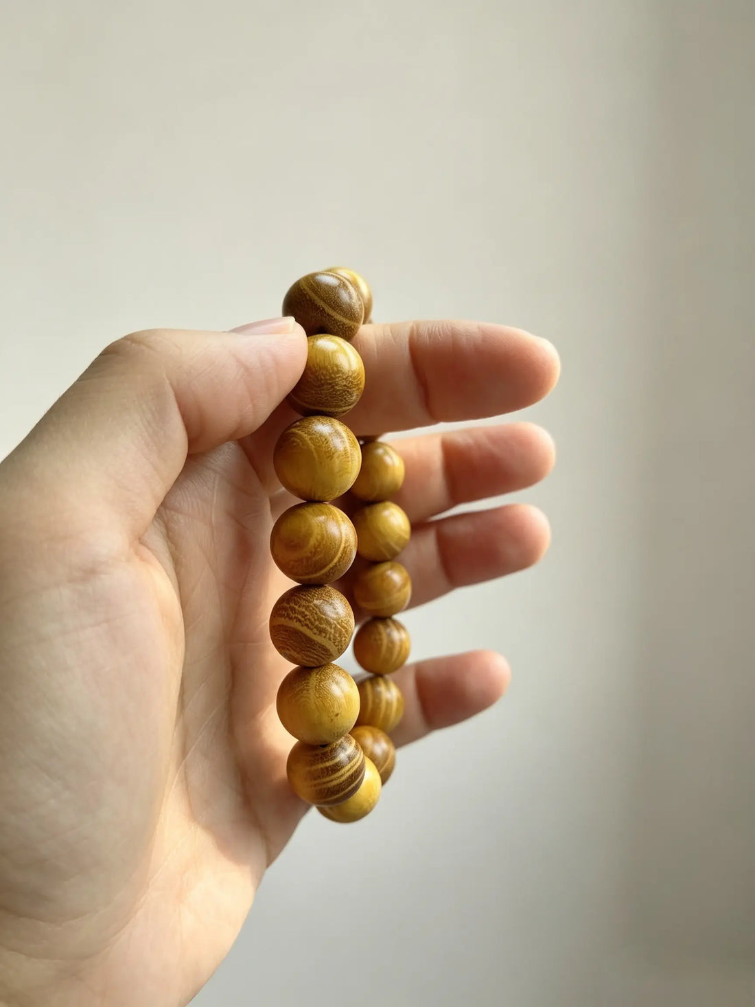 Wooden bracelet beads held gently in hand, calming and grounded