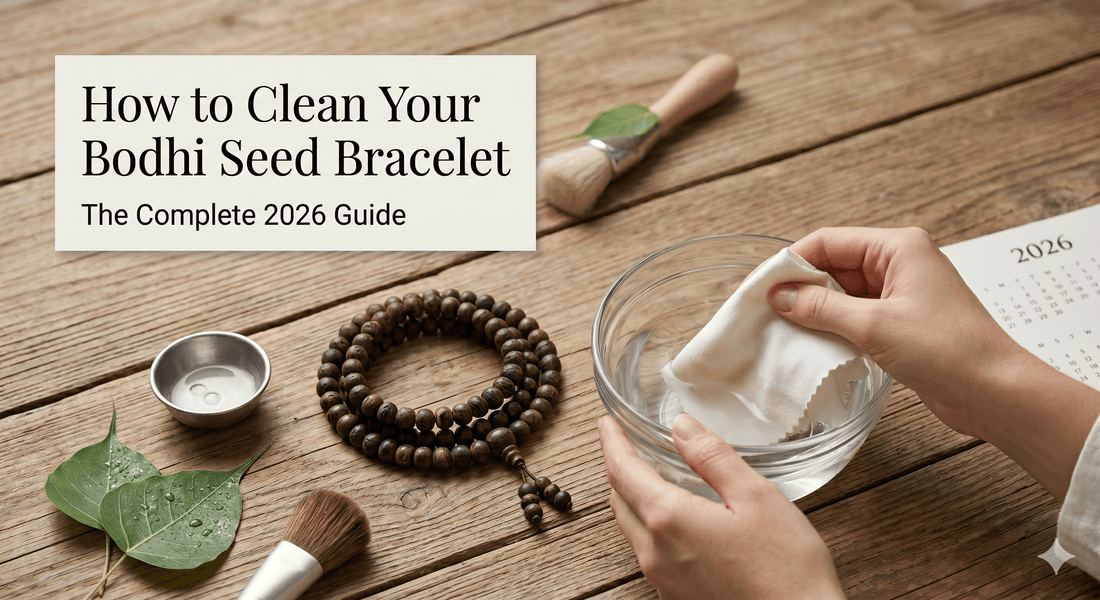 Hands cleaning a dark bodhi seed bracelet on a wooden table with a brush and small bowl.