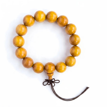 A handcrafted golden sandalwood wood bead bracelet with a brown knot, isolated on a pure white background for product details display.